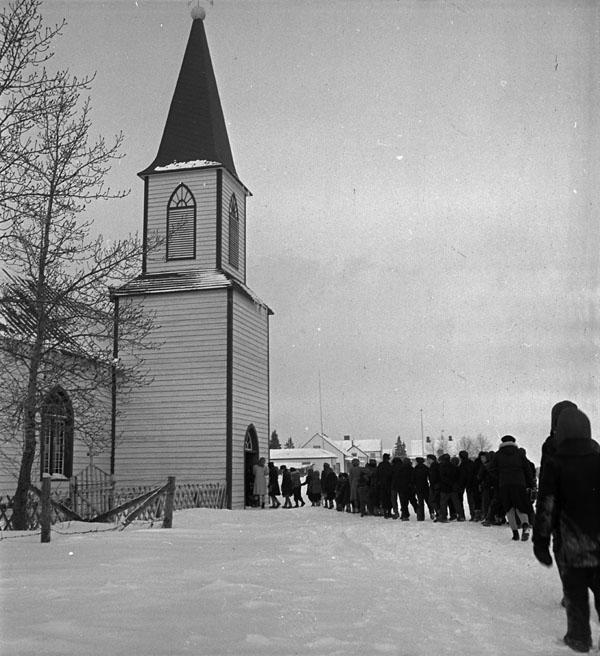 Bishop Horden Hall (Moose Factory Indian Residential School), students walking in the snow to a service at St. Thomas Anglican Church, Moose Factory Island, January 1946